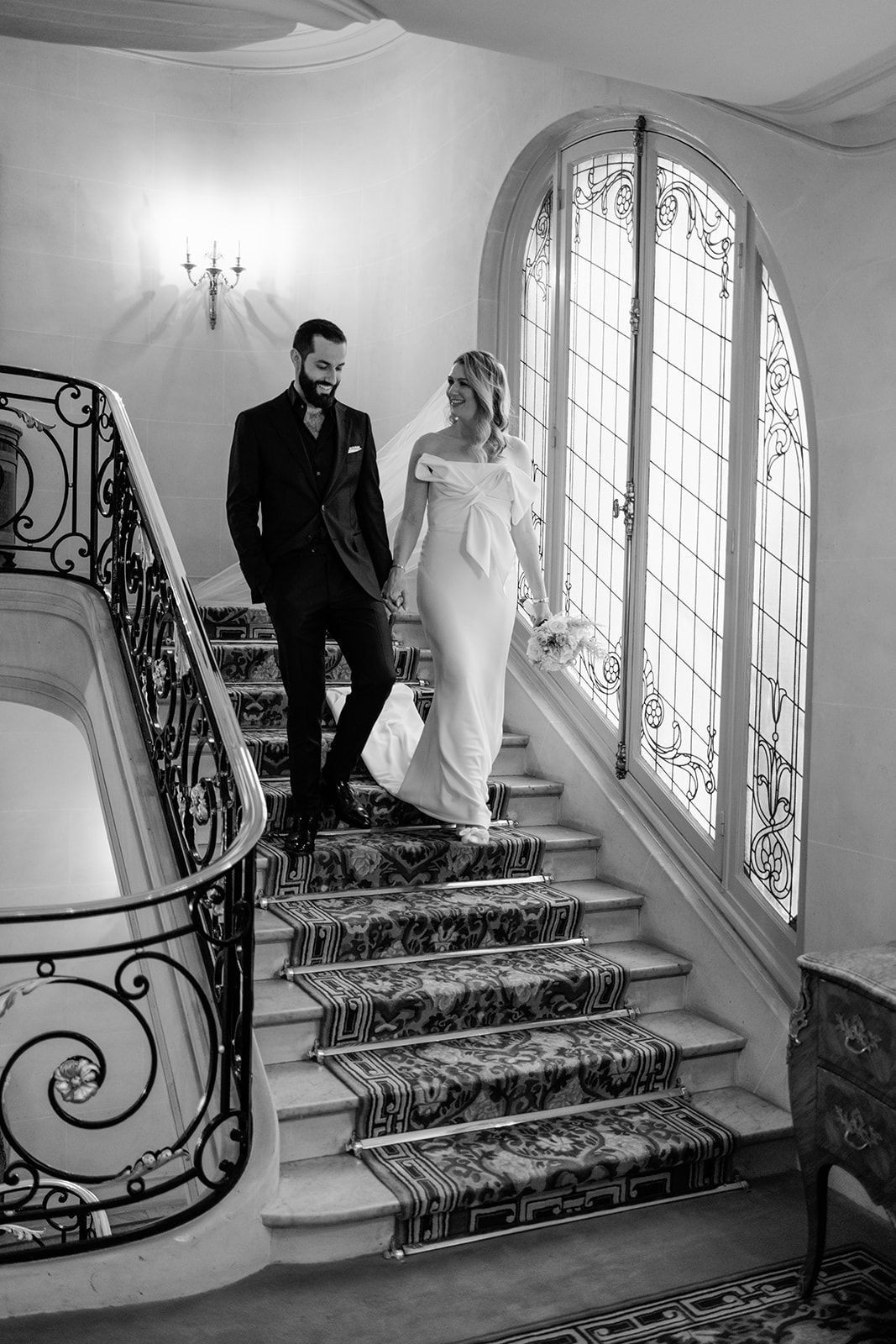 Editorial black and white portrait of newlyweds on the Plaza Athénée staircase